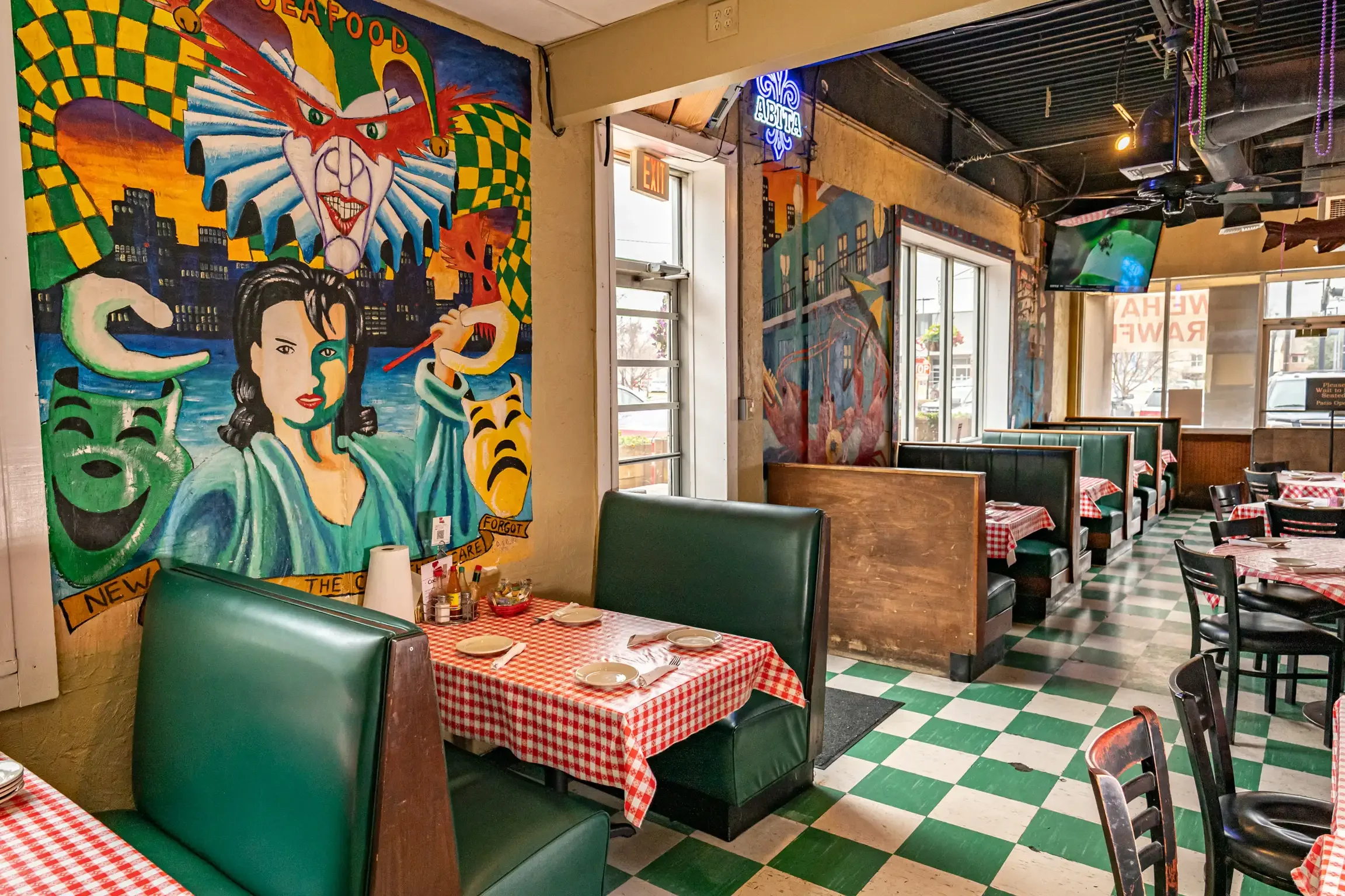 Colorful restaurant interior with vibrant murals and checkered tablecloths