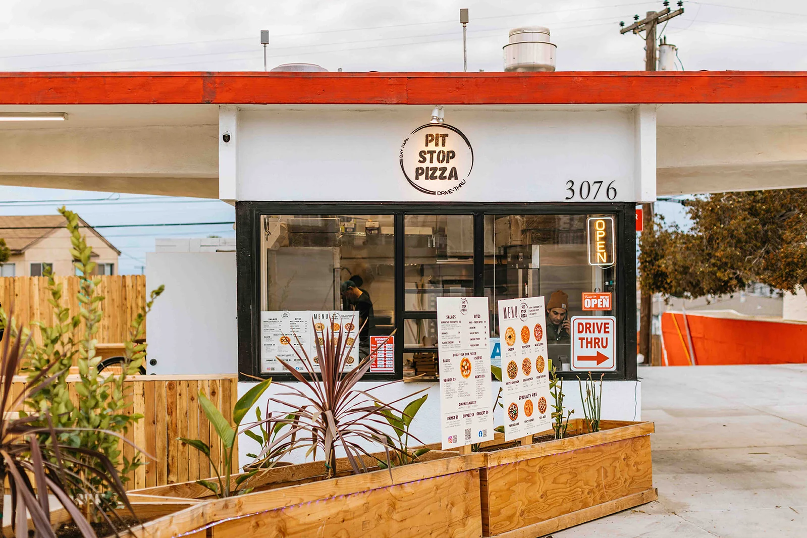 Exterior of Pit Stop Pizza with drive-thru sign
