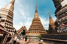 Stupas at Wat Pho in Bangkok, Thailand under a clear blue sky