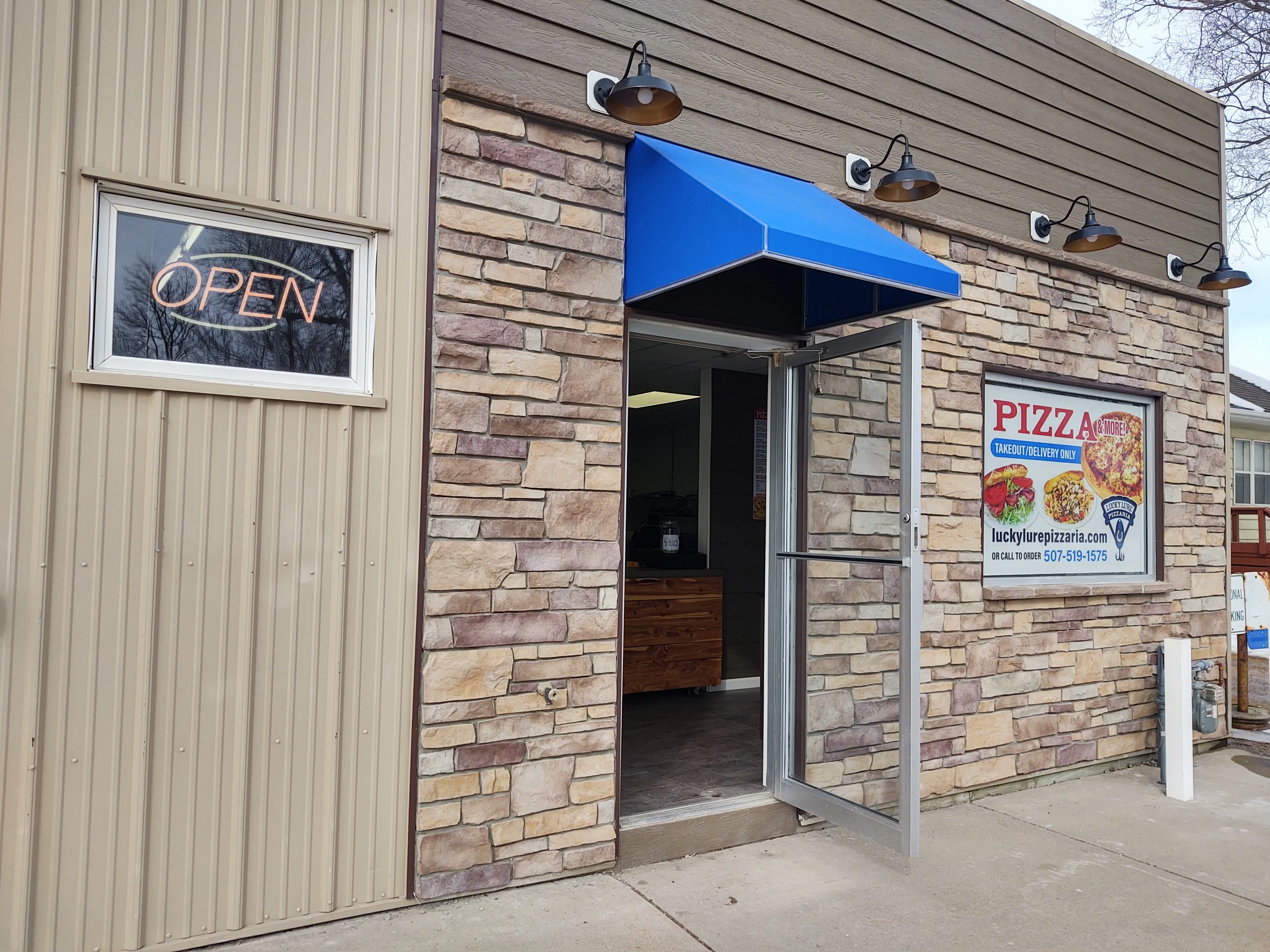 Entrance of a cozy pizza restaurant with an open sign