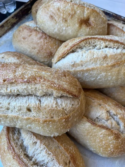 Freshly baked artisan rolls on a tray