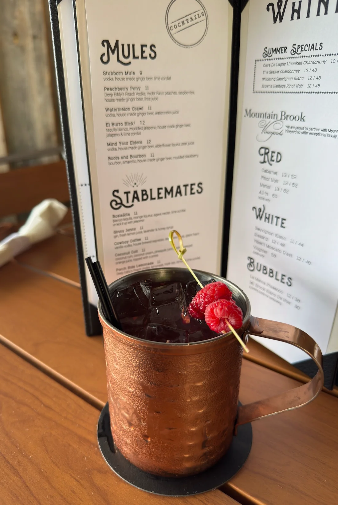 Craft cocktail served in a copper mug with raspberries