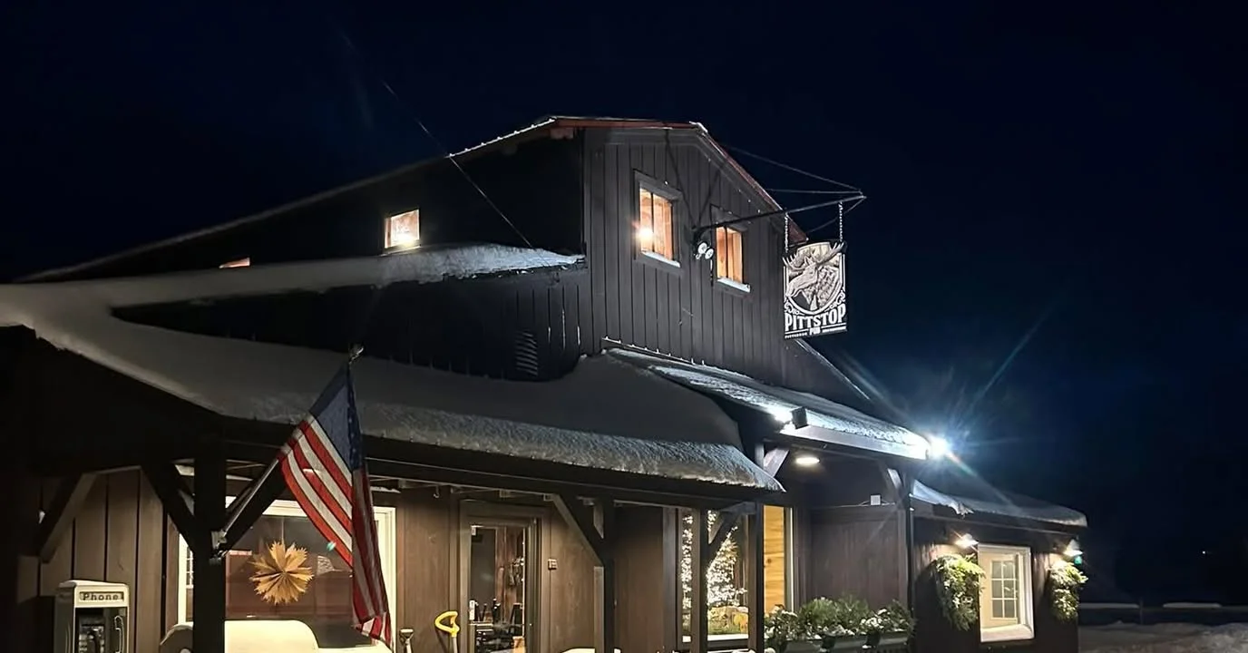 Charming restaurant exterior at night with snow and warm lighting