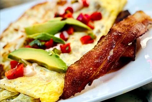 Delicious Mexican breakfast omelette with avocado and bacon