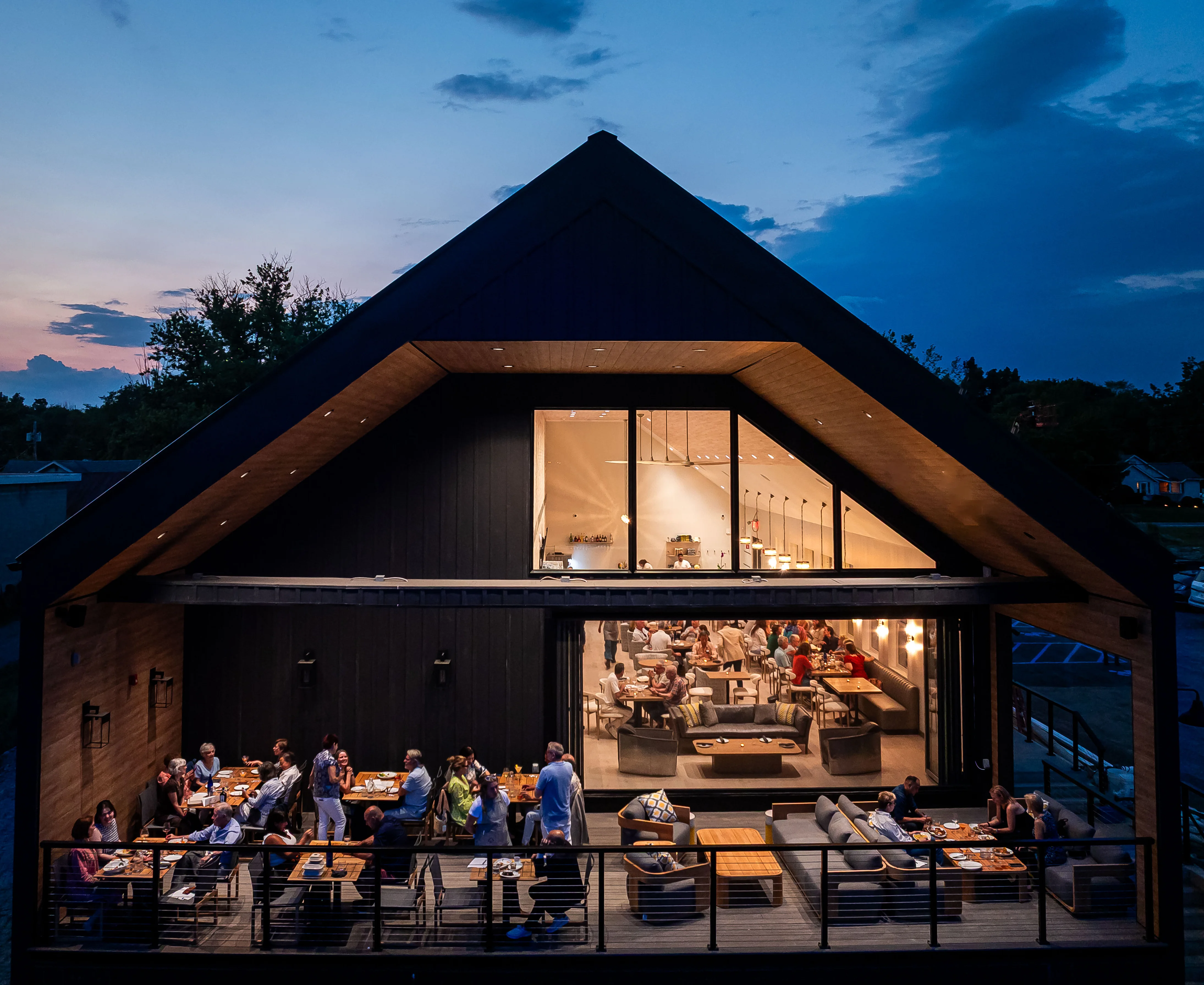 Modern restaurant exterior at dusk with outdoor dining area