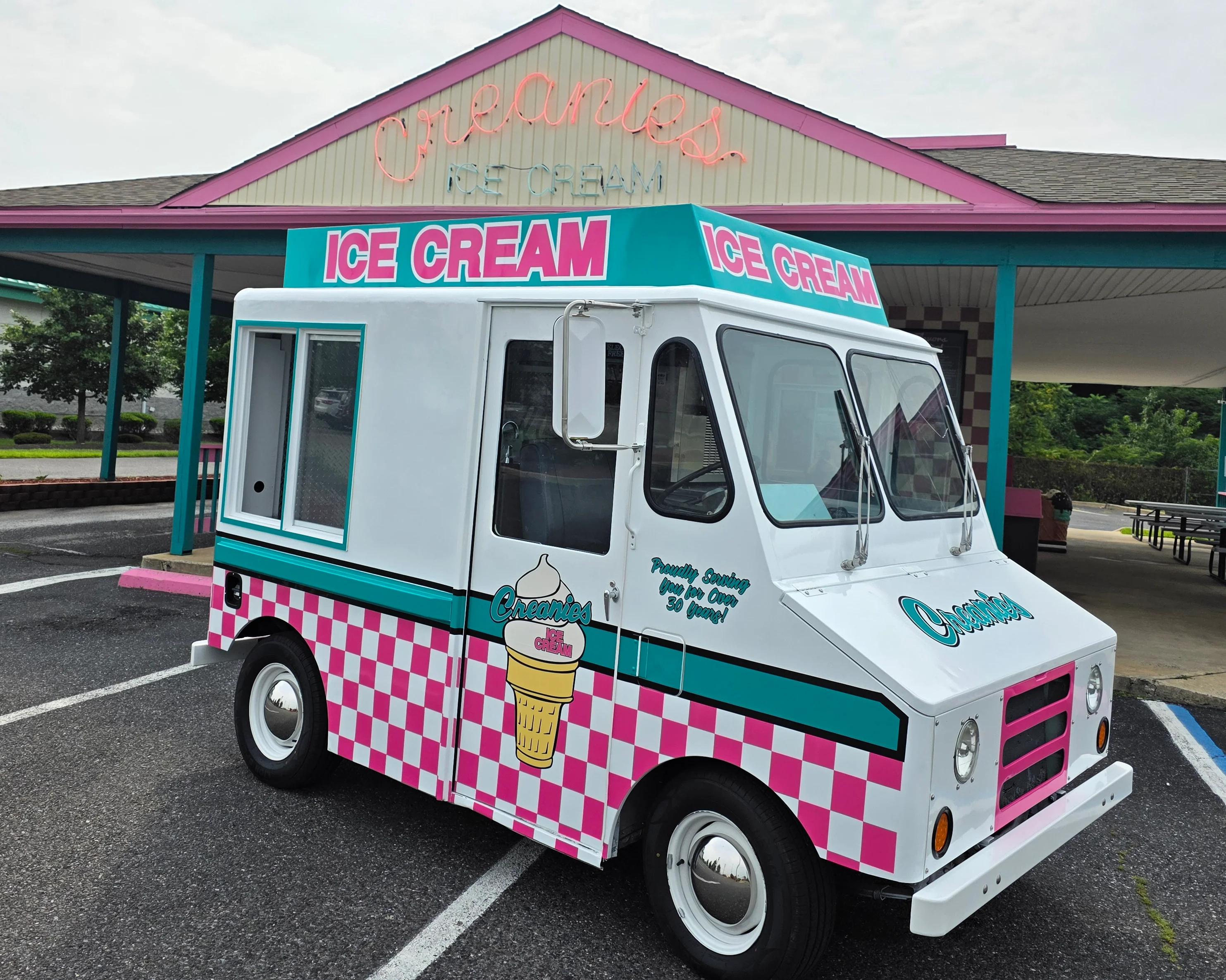 Colorful ice cream truck parked outside a retro ice cream stand