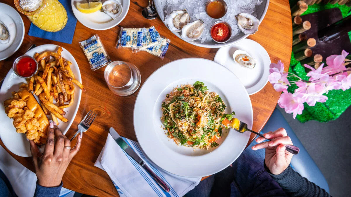 Seafood platter with fried shrimp, fries, and fresh oysters in a vibrant setting