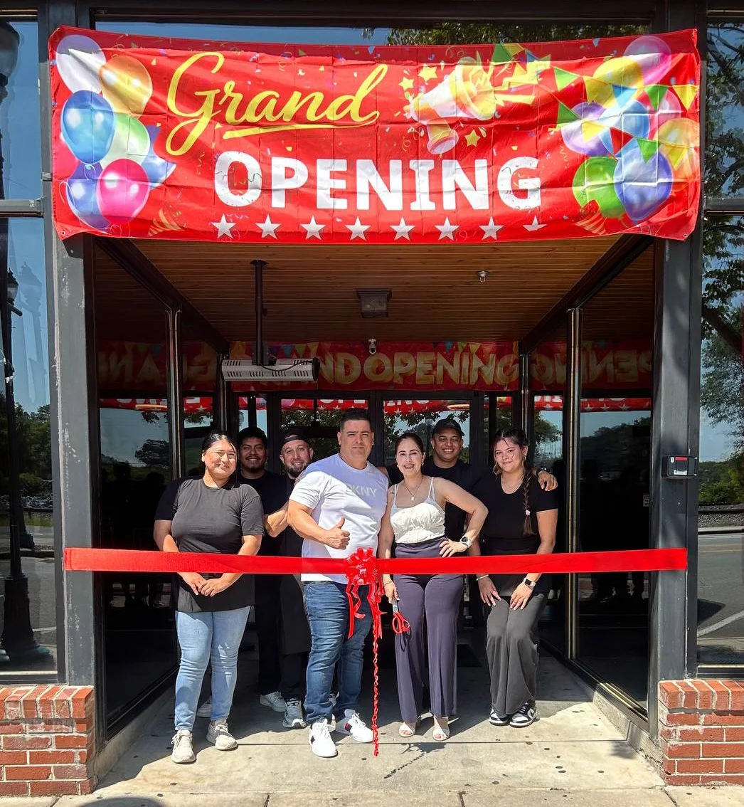 Team celebrating grand opening of a new restaurant with a ribbon cutting ceremony
