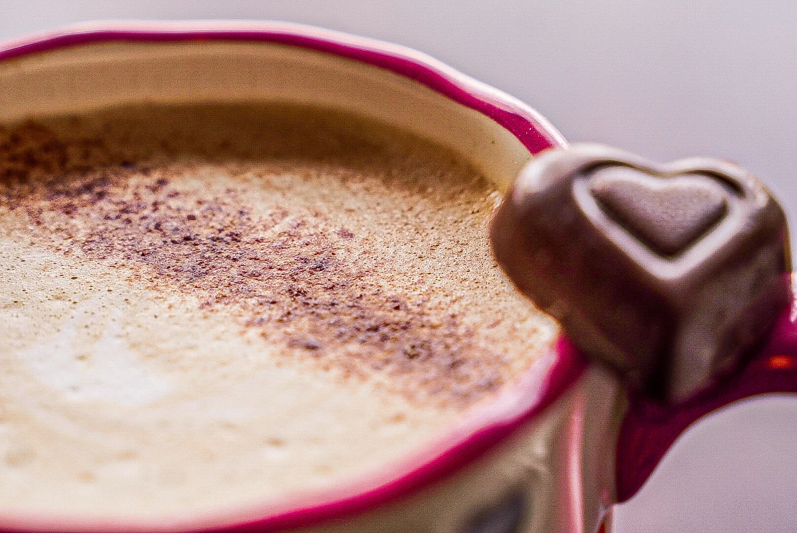 Creamy cappuccino topped with cocoa powder and a chocolate heart