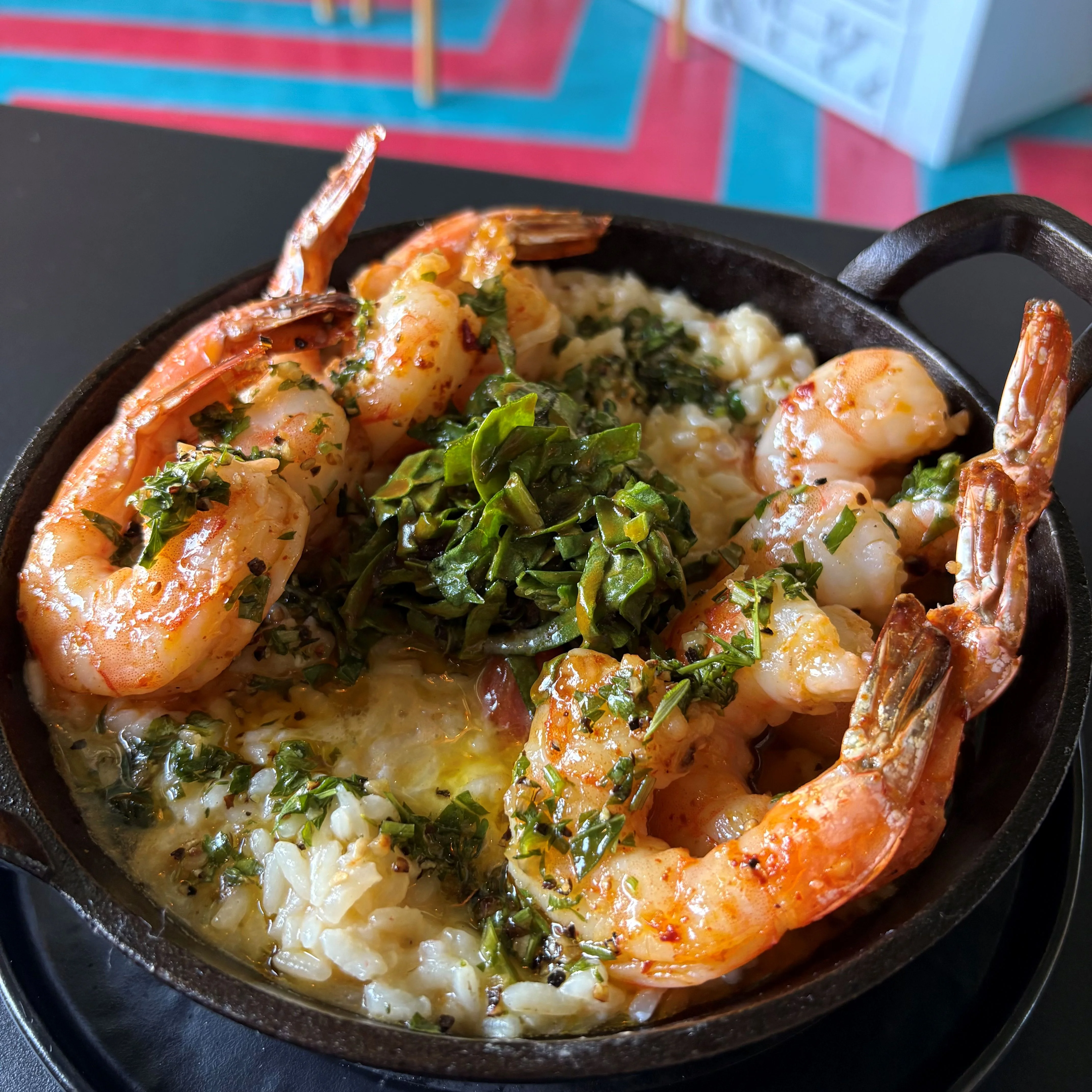Shrimp and grits served in a cast iron skillet