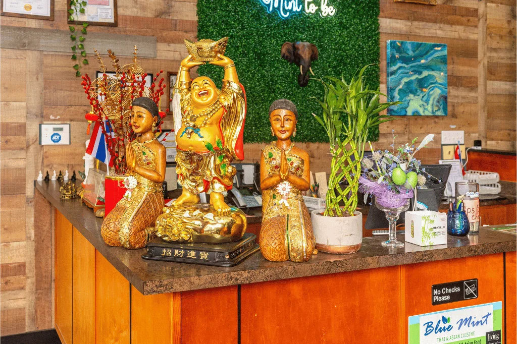 Welcoming restaurant reception with decorative statues and plants
