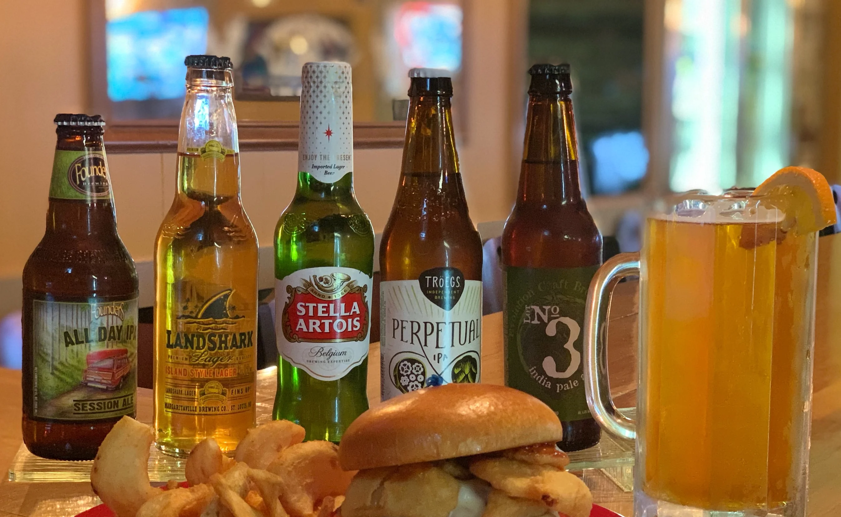 Juicy cheeseburger with crispy fries and craft beers on a bar counter