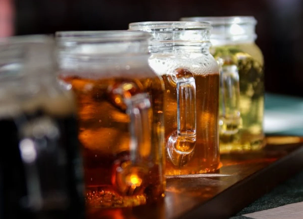 Assorted craft beers in mason jars on a wooden tray