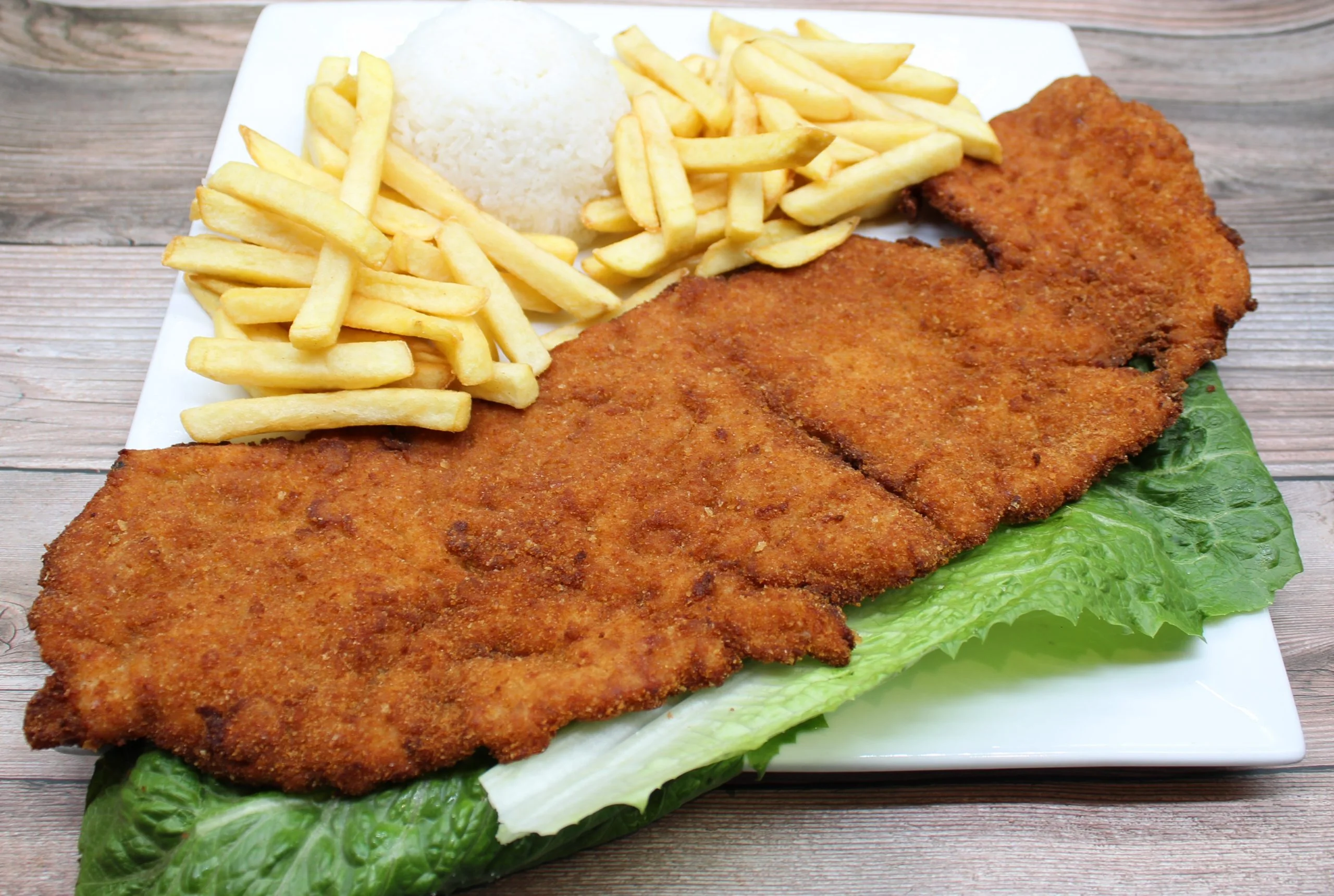 Crispy Peruvian chicken milanesa with fries and rice