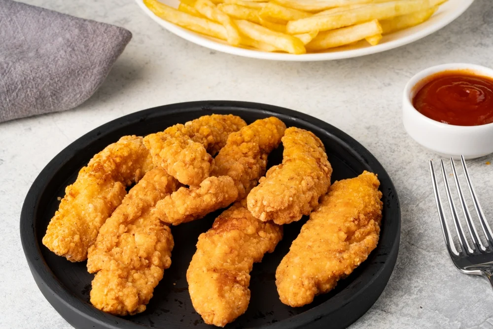 Crispy chicken tenders served with fries and dipping sauce