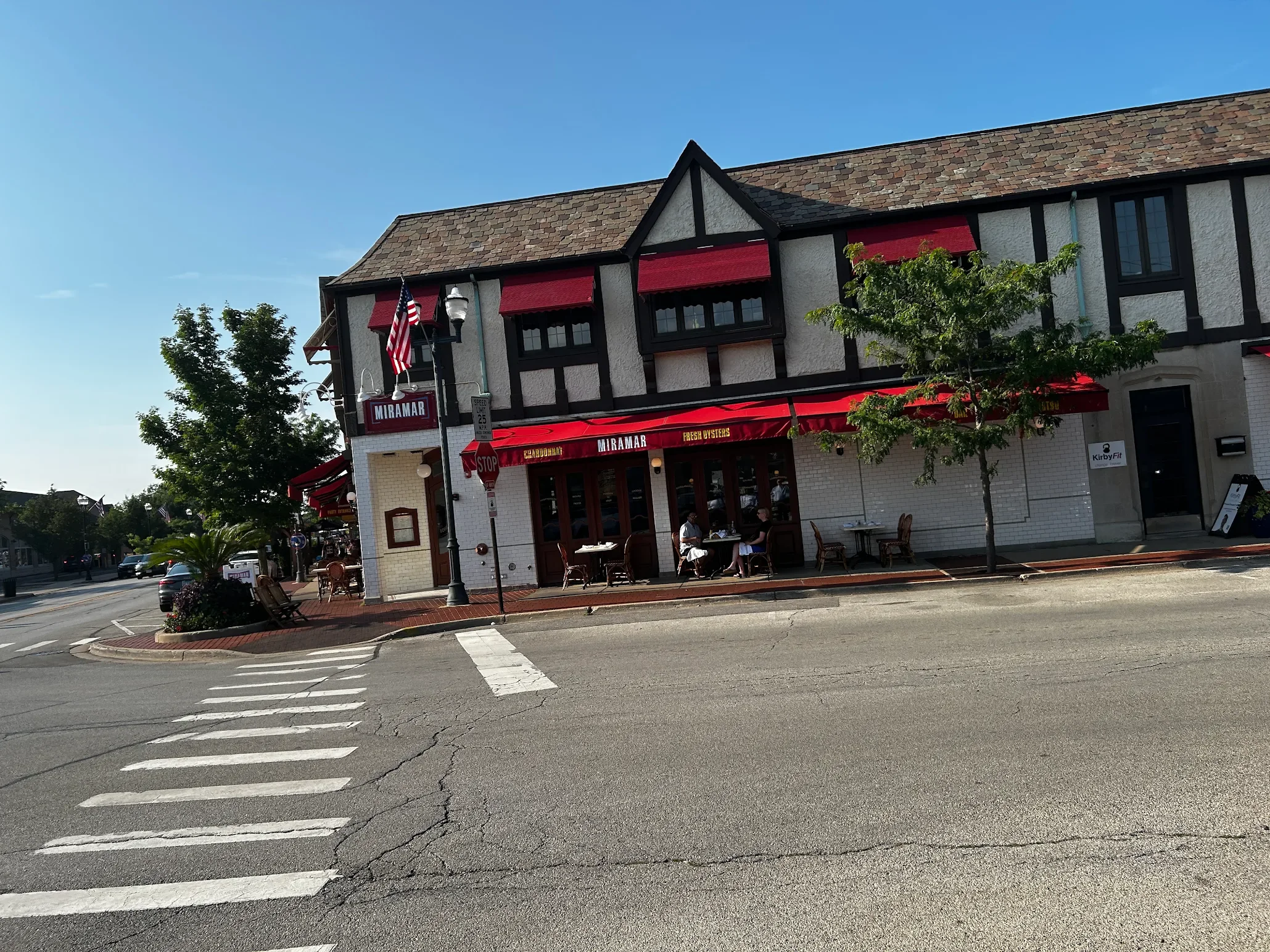 Charming restaurant exterior with red awnings and outdoor seating