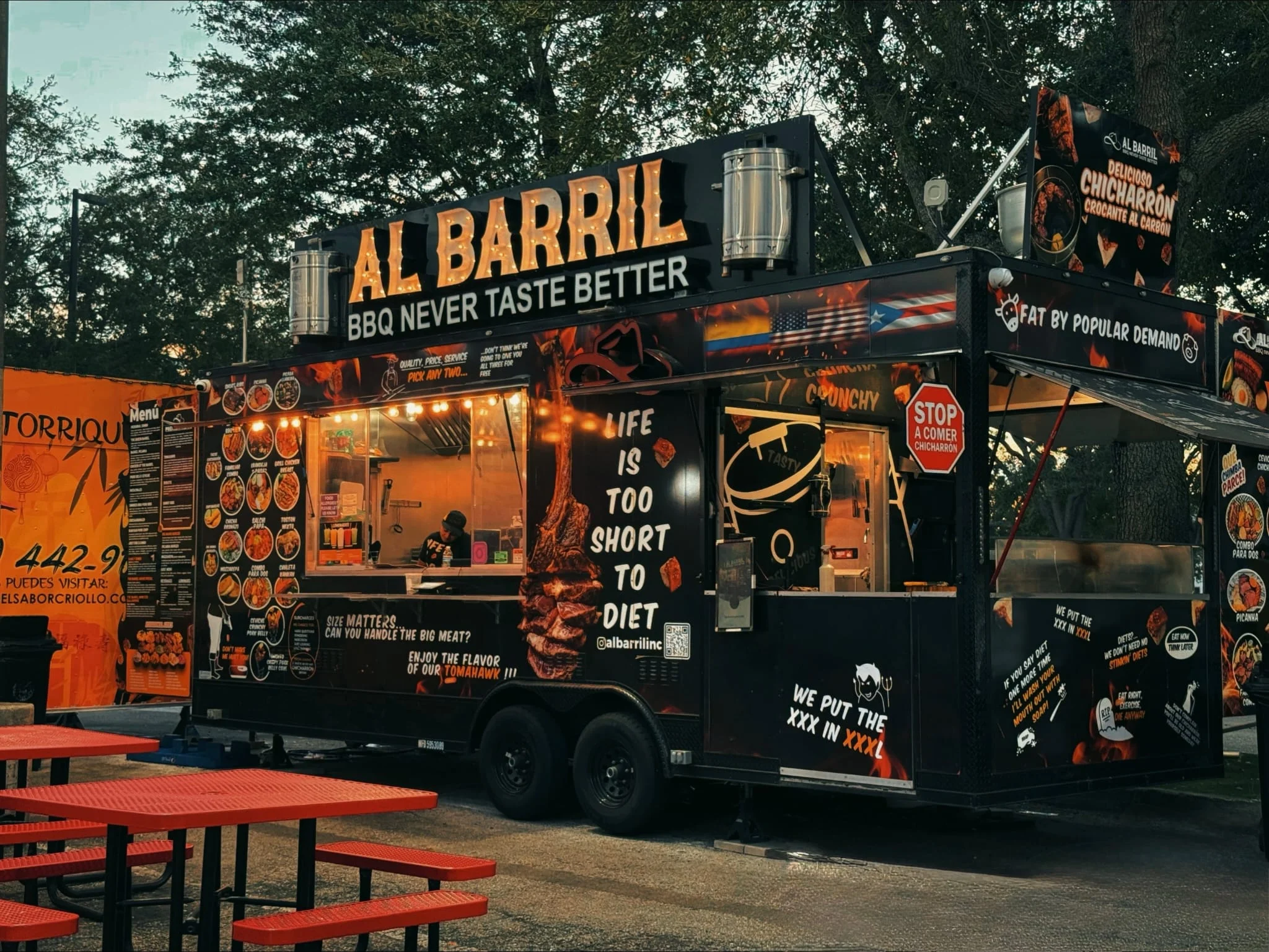 Vibrant BBQ food truck serving chicharrón and grilled meats