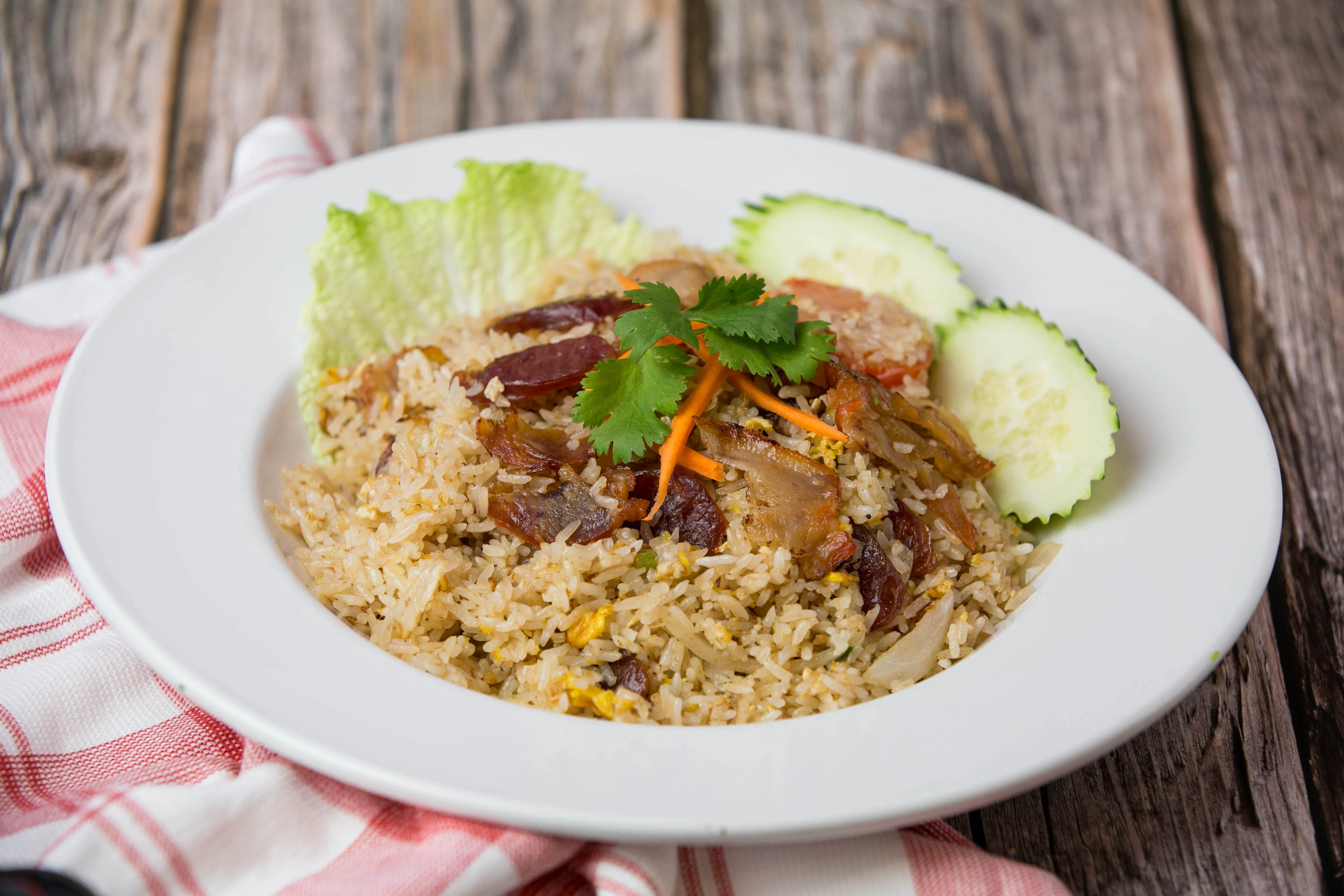 Plate of Malaysian Nasi Goreng with vegetables and garnishes