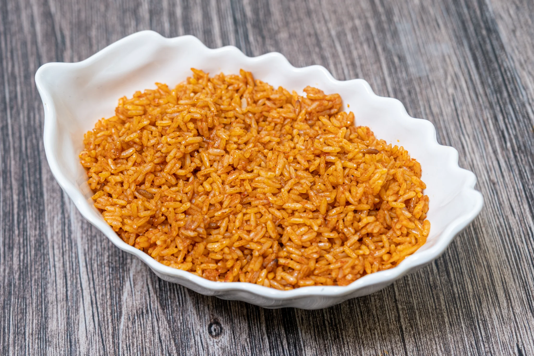 Nigerian jollof rice served in a white dish