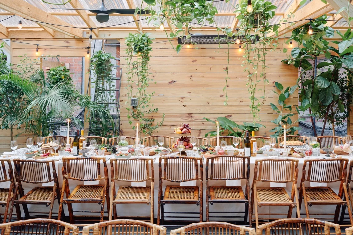 Elegant dining setup in a greenhouse with lush greenery