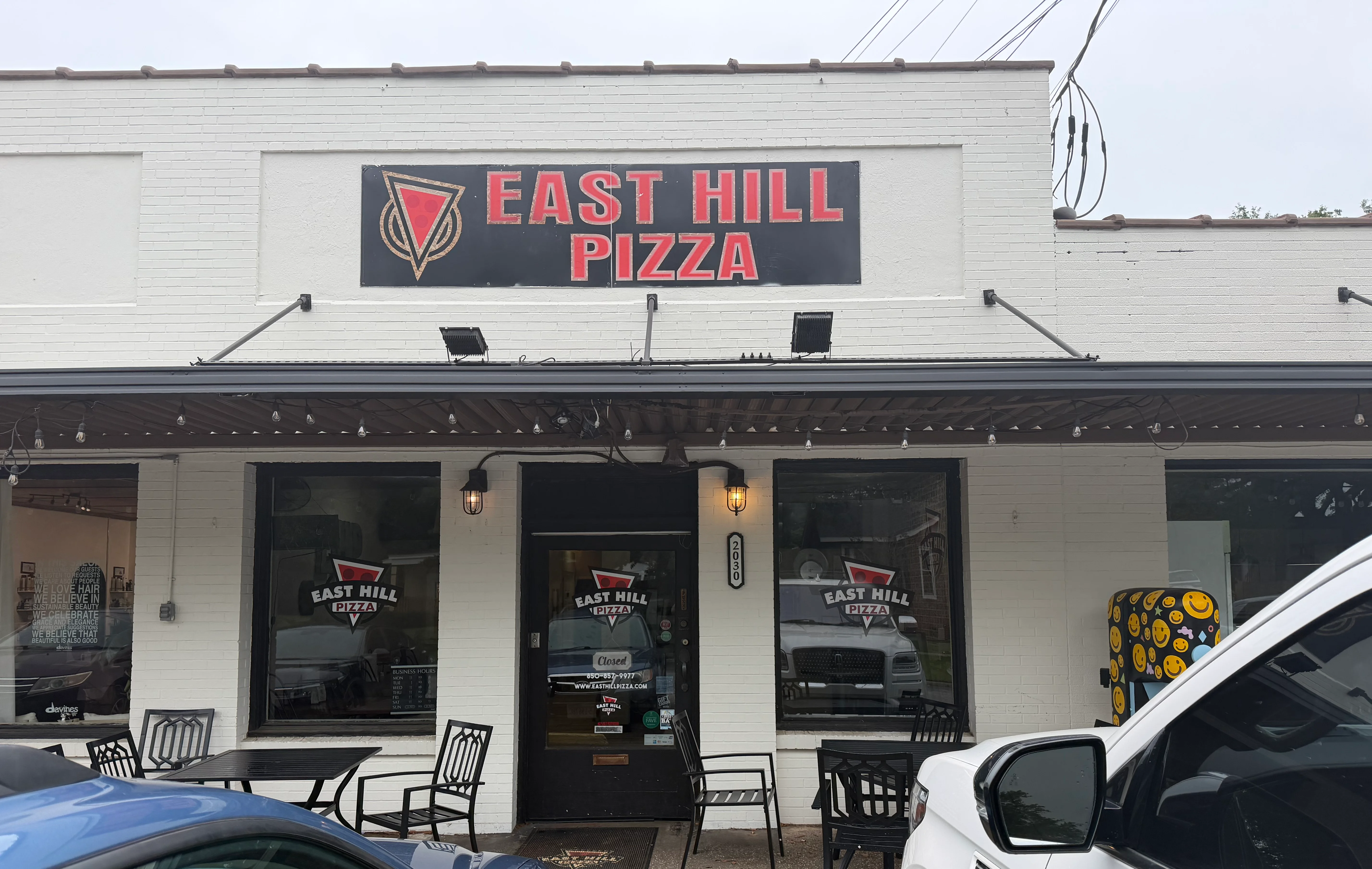 Exterior view of East Hill Pizza restaurant with outdoor seating
