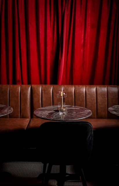 Cozy restaurant interior with red curtains and brick walls