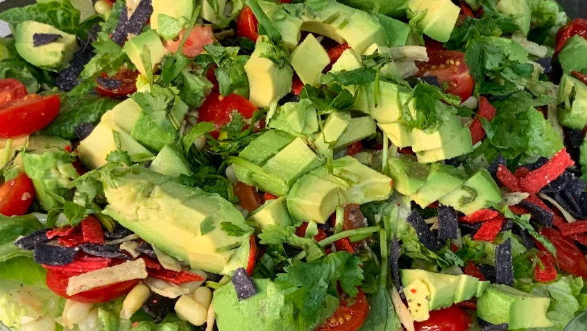 Our Scottsdale salad has Romaine with avocado, yellow corn, black beans, grape tomato, cheddar cheese, cilantro, and corn strips served with our creamy avocado (vegan) dressing.