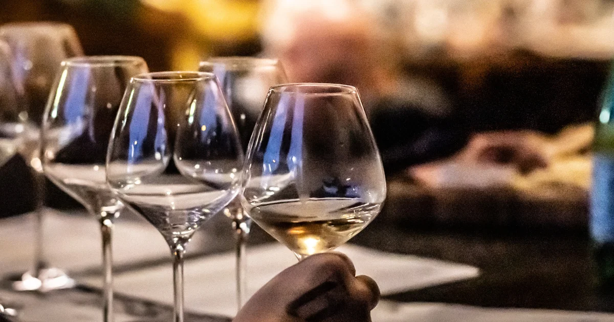 Wine tasting setup with elegant glasses and a hand holding a glass