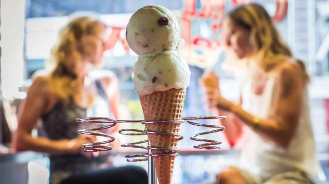 Delicious ice cream cone with two scoops in a vibrant café setting