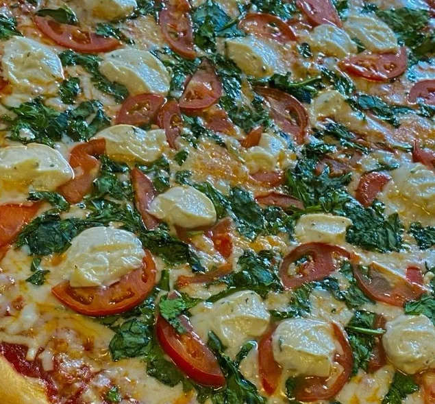 Delicious Margherita pizza topped with fresh basil and tomatoes