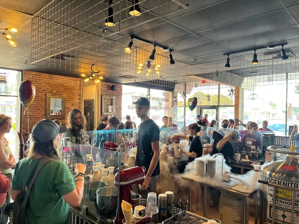 Busy café interior with customers and staff preparing drinks