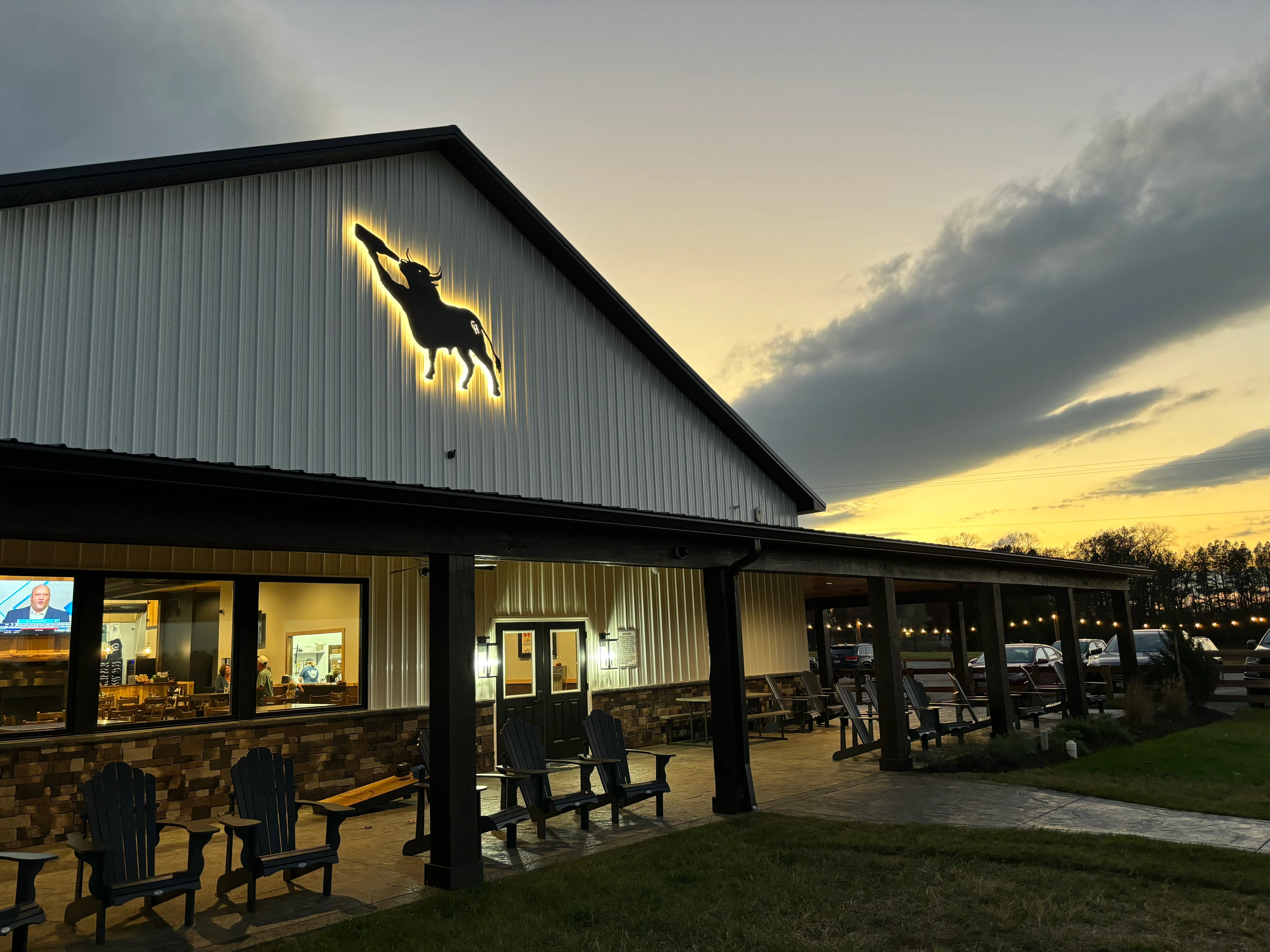 Exterior of Chilly Hollow Brewing Co. at nighttime with backlit bull logo