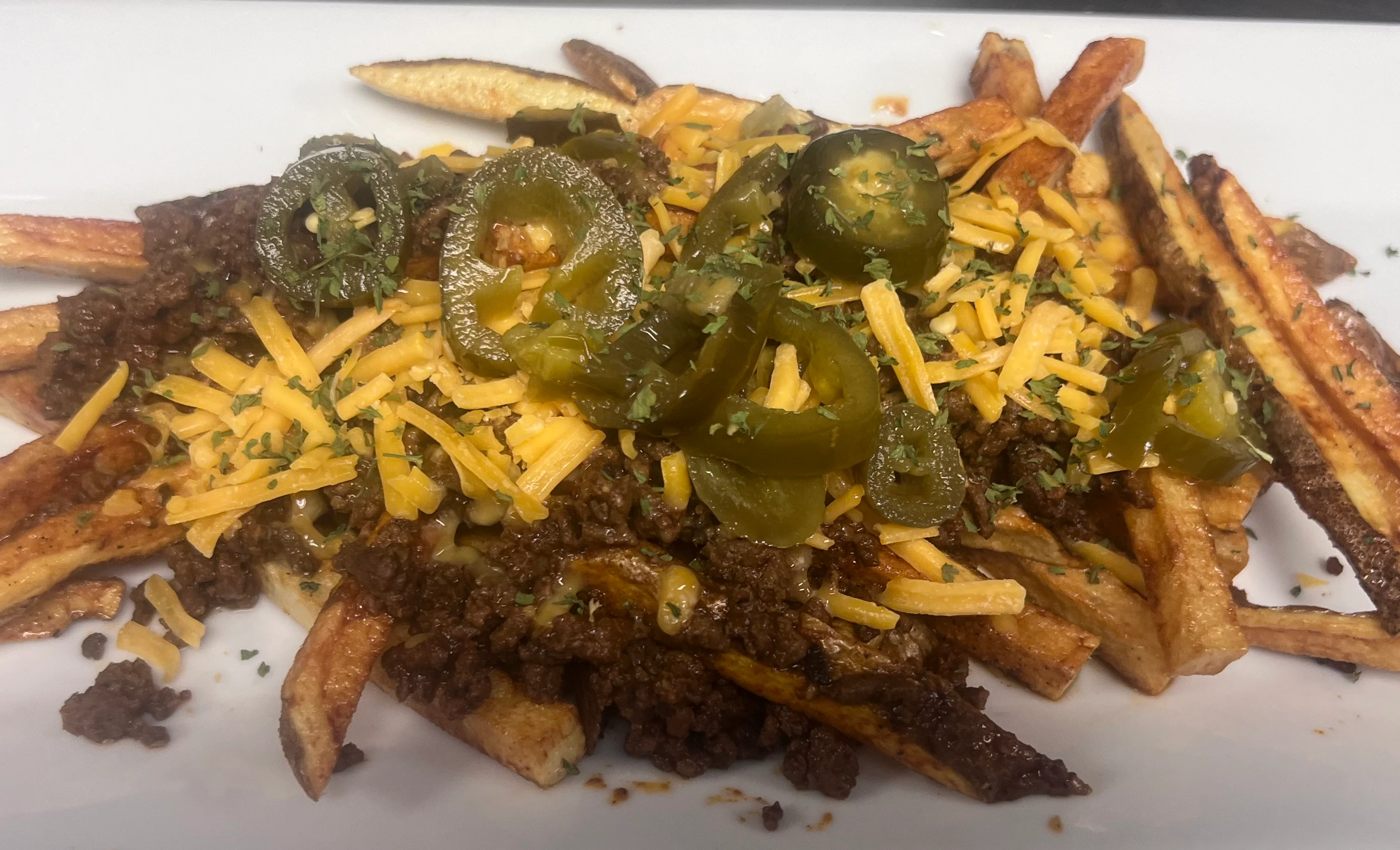 Loaded chili cheese fries topped with jalapeños