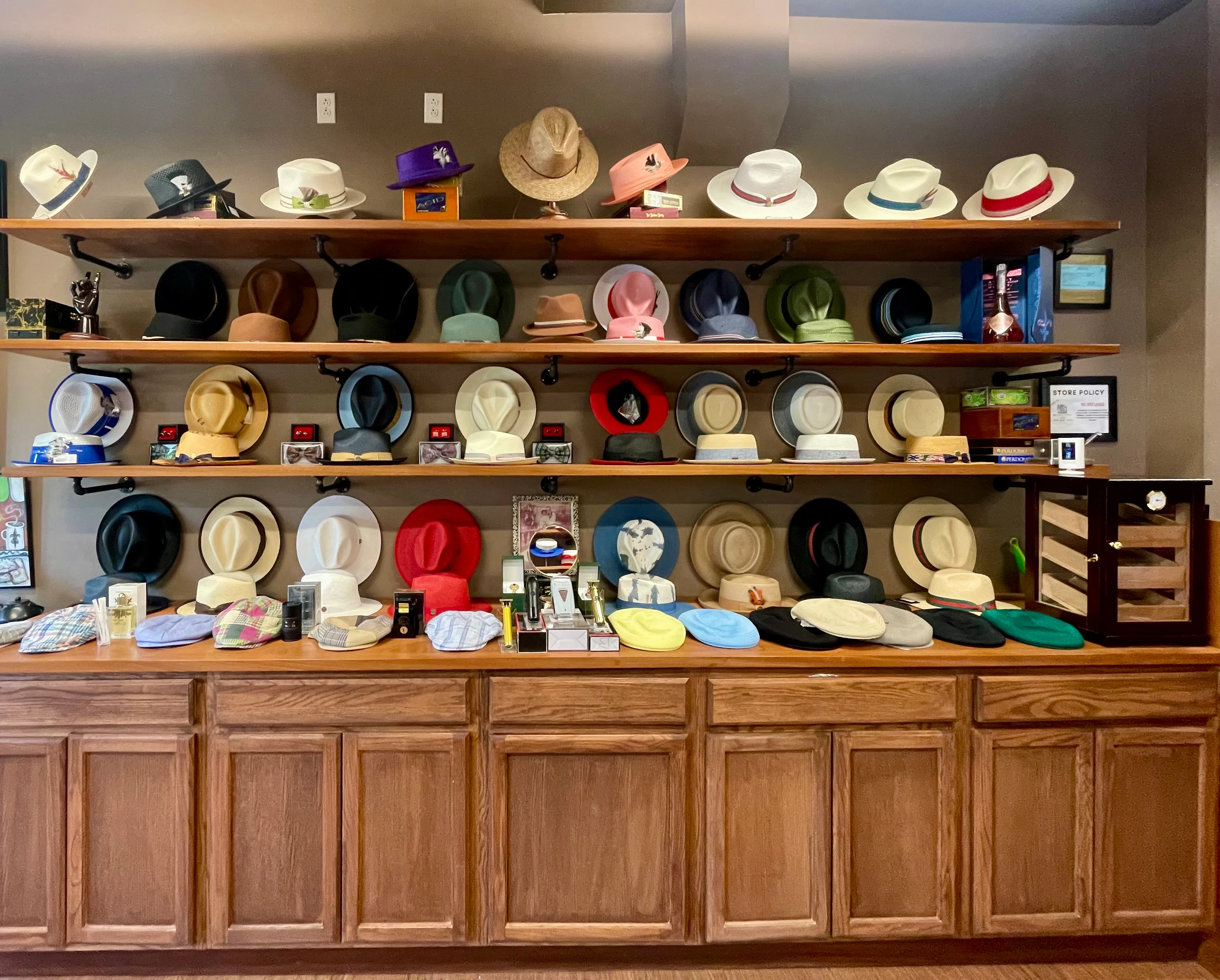 Display of various stylish hats on wooden shelves