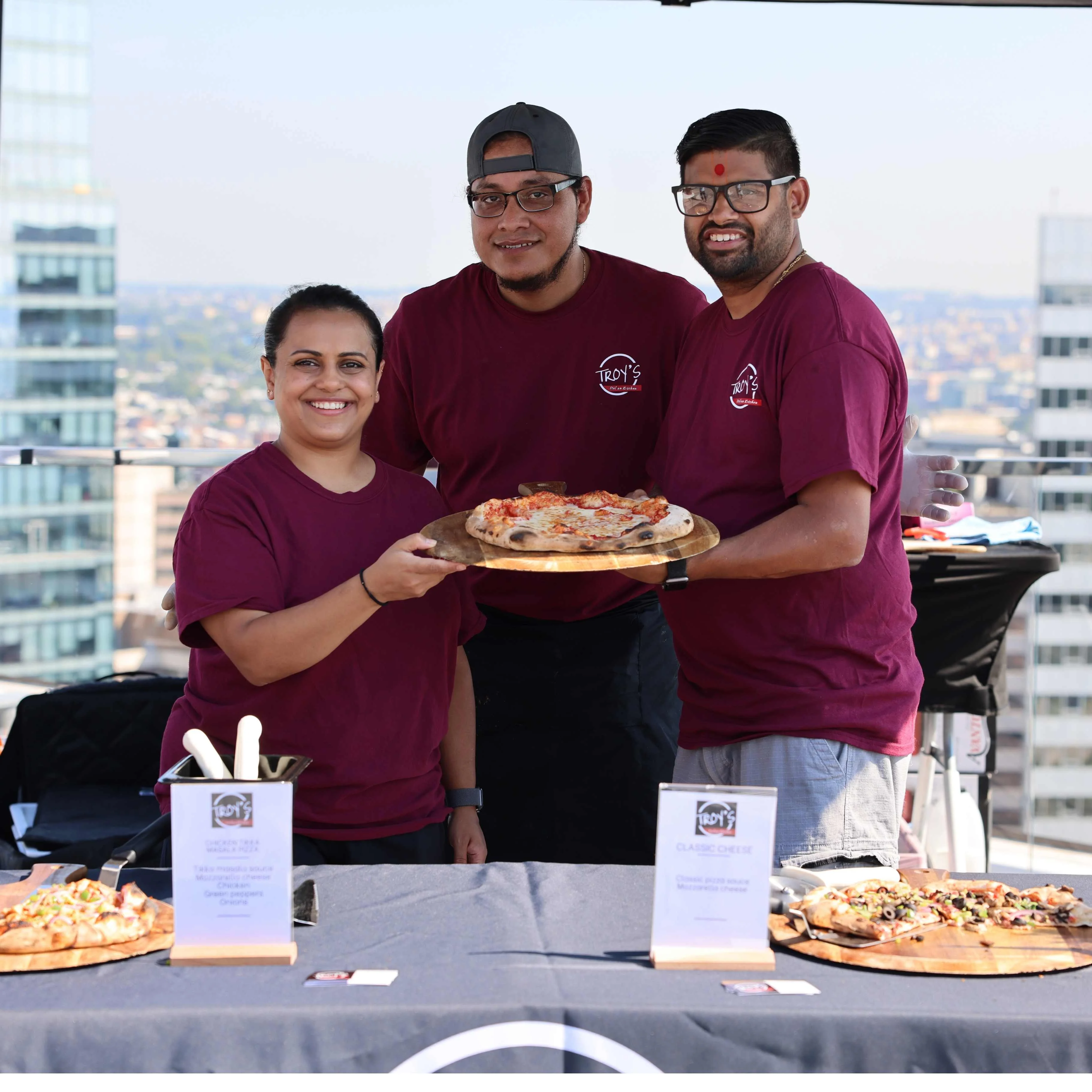 A variety of dishes served on a table, including pizzas, pasta with marinara sauce, and fried items on a platter.
