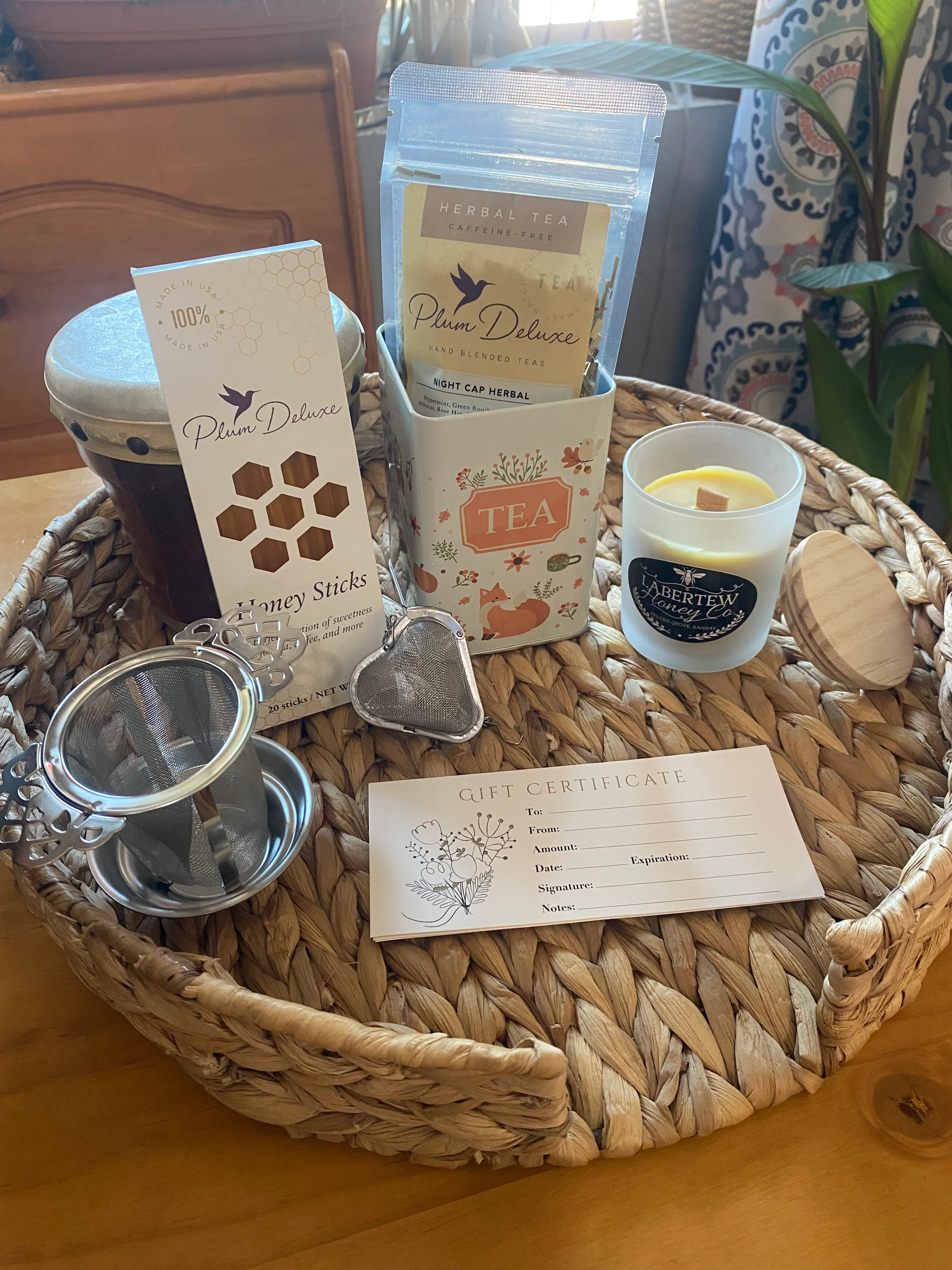 Gift basket with herbal tea, honey sticks, and a candle