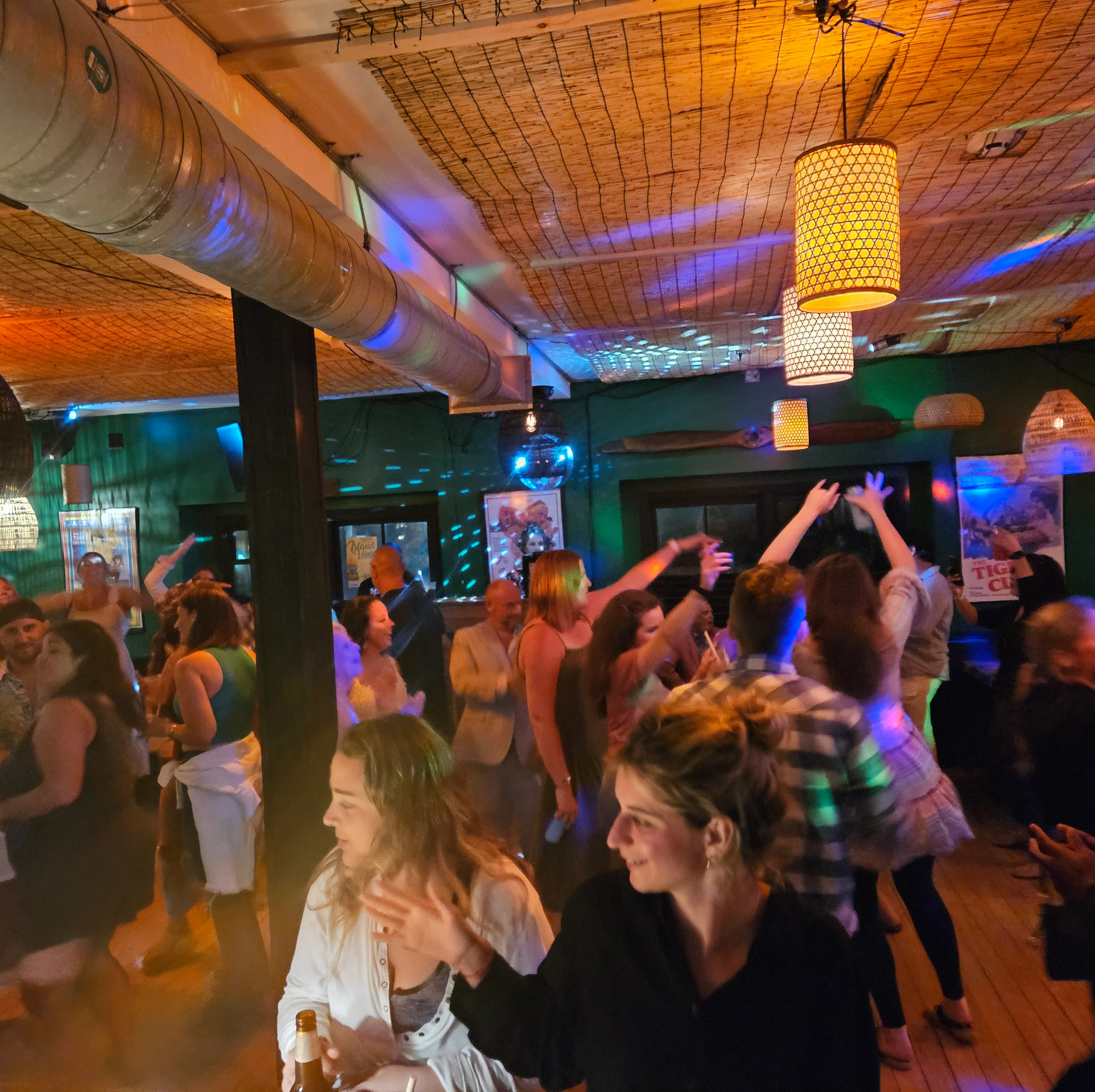 Vibrant restaurant interior with dancing patrons and colorful lighting