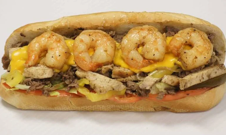 Shrimp and steak sub sandwich with melted cheese