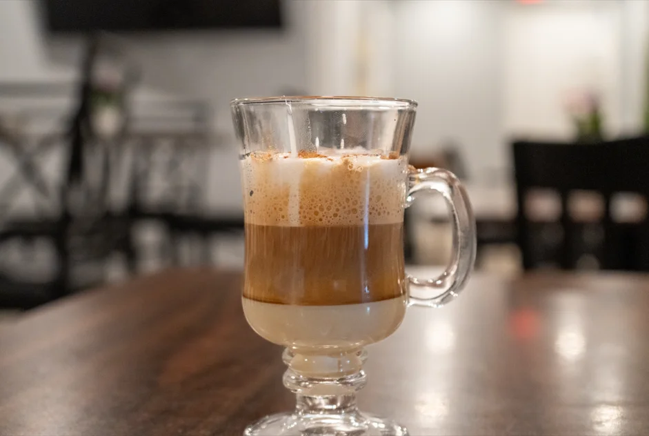 Layered latte in a glass cup with frothy milk