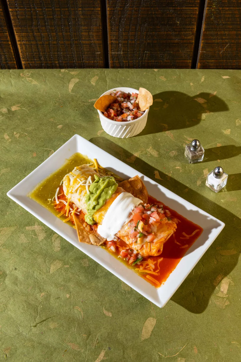 Mexican Flag Burrito served with guacamole, sour cream, pico de gallo, and colorful sauces at Friducha in Brooklyn, NY.