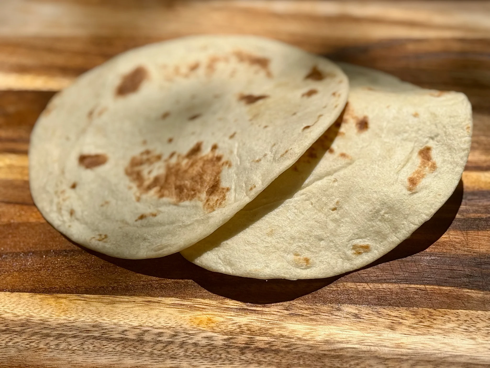Freshly made flour tortillas on a wooden board