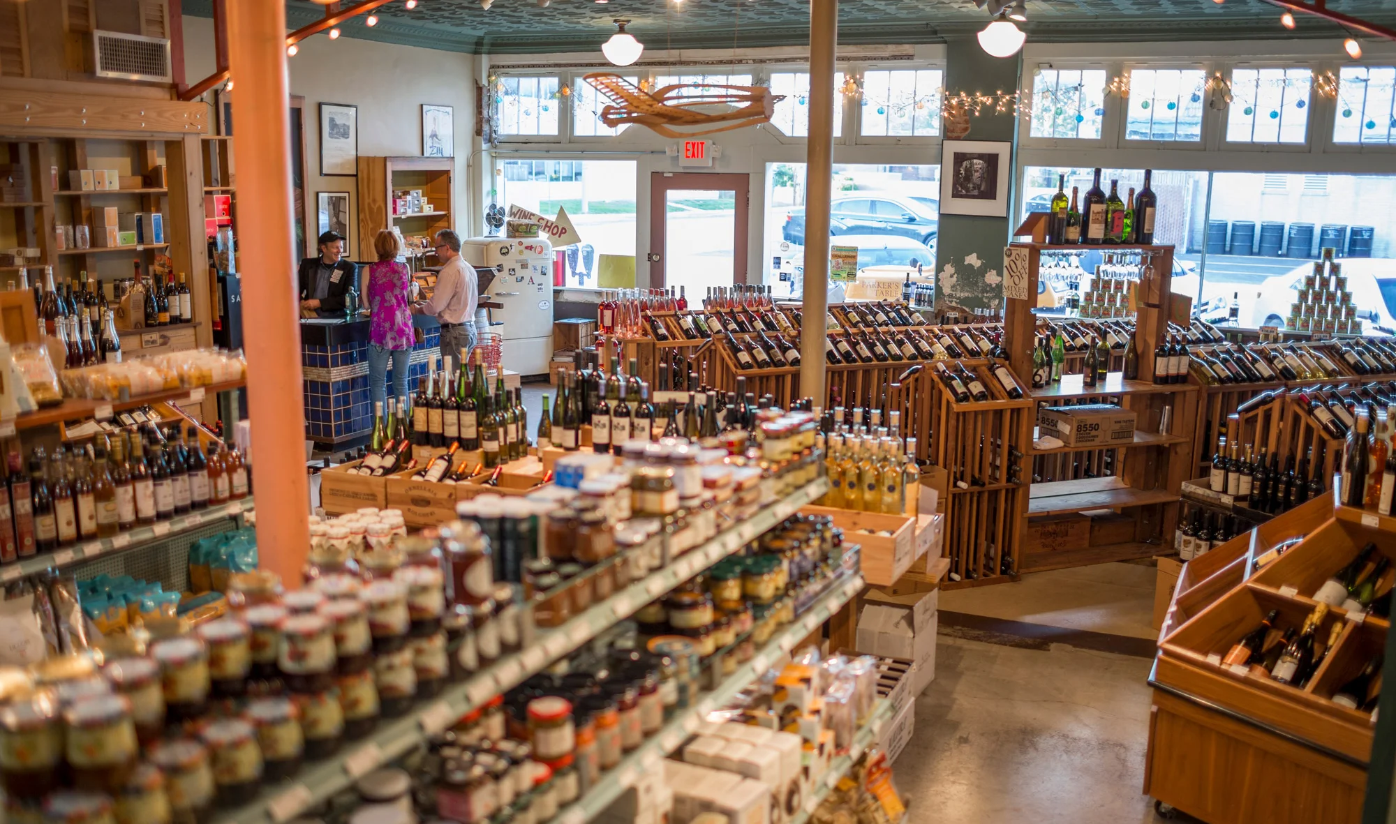 Bottles of wine, jars of goodies, Jon Parker happily helping happy a pair of customers