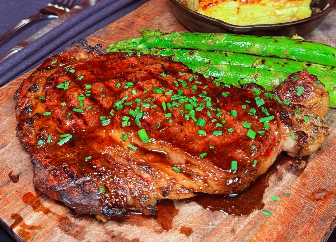Grilled ribeye steak with asparagus and cheesy potato gratin