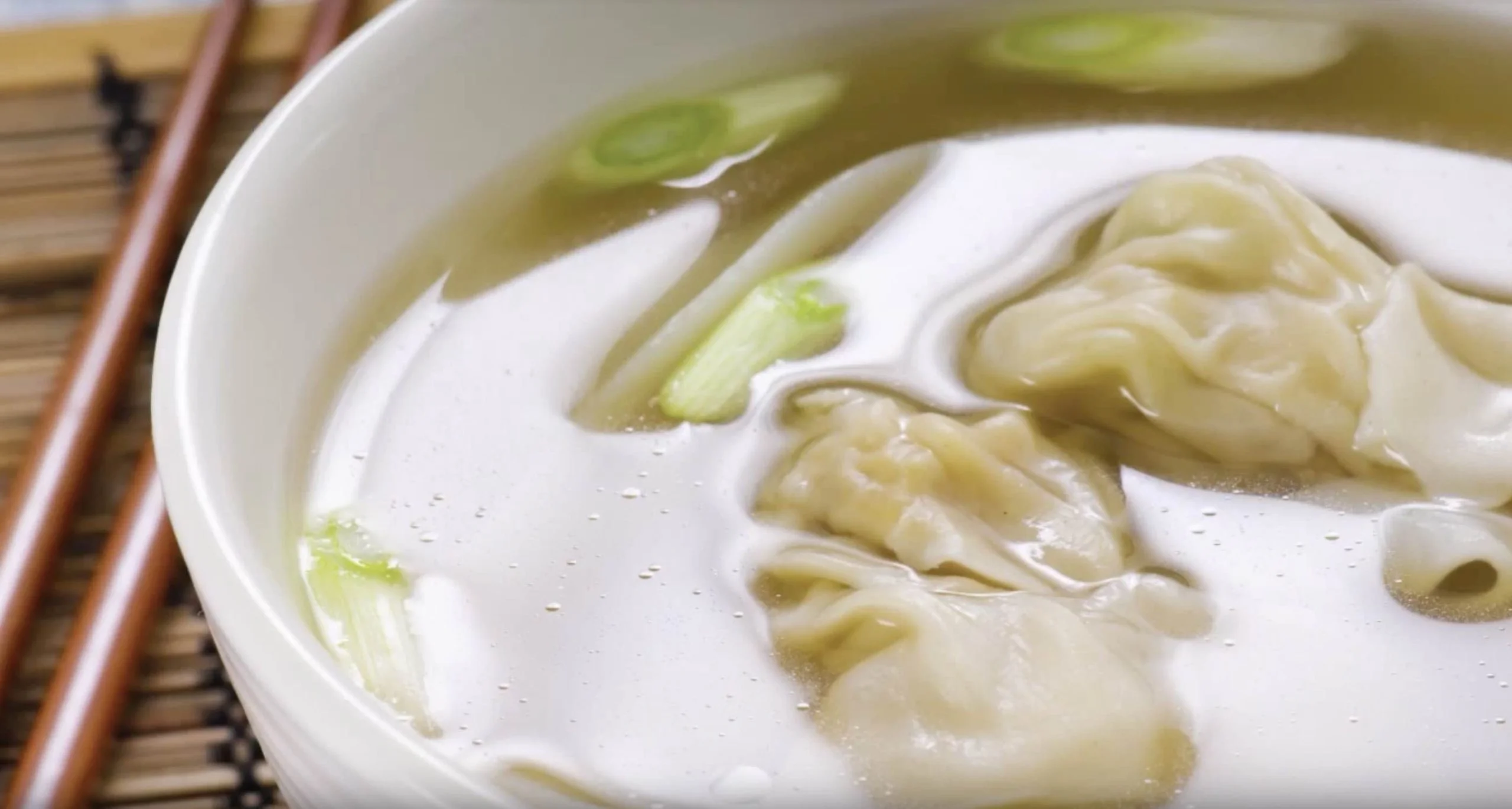 Bowl of Chinese wonton soup with scallions