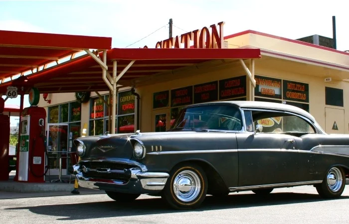 Classic vintage car parked at a retro gas station