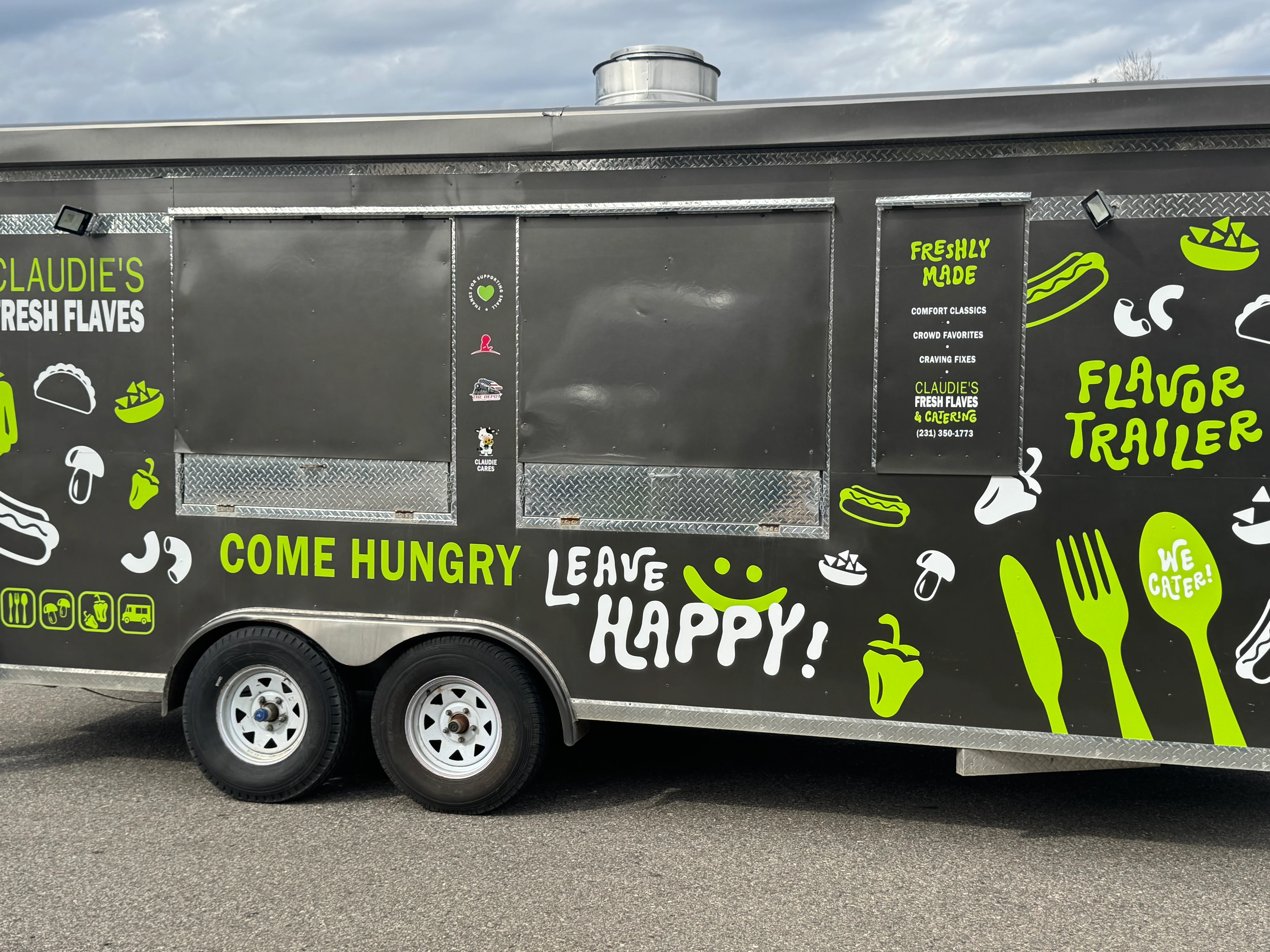 Food truck with vibrant graphics promoting Claudie's Fresh Flaves.