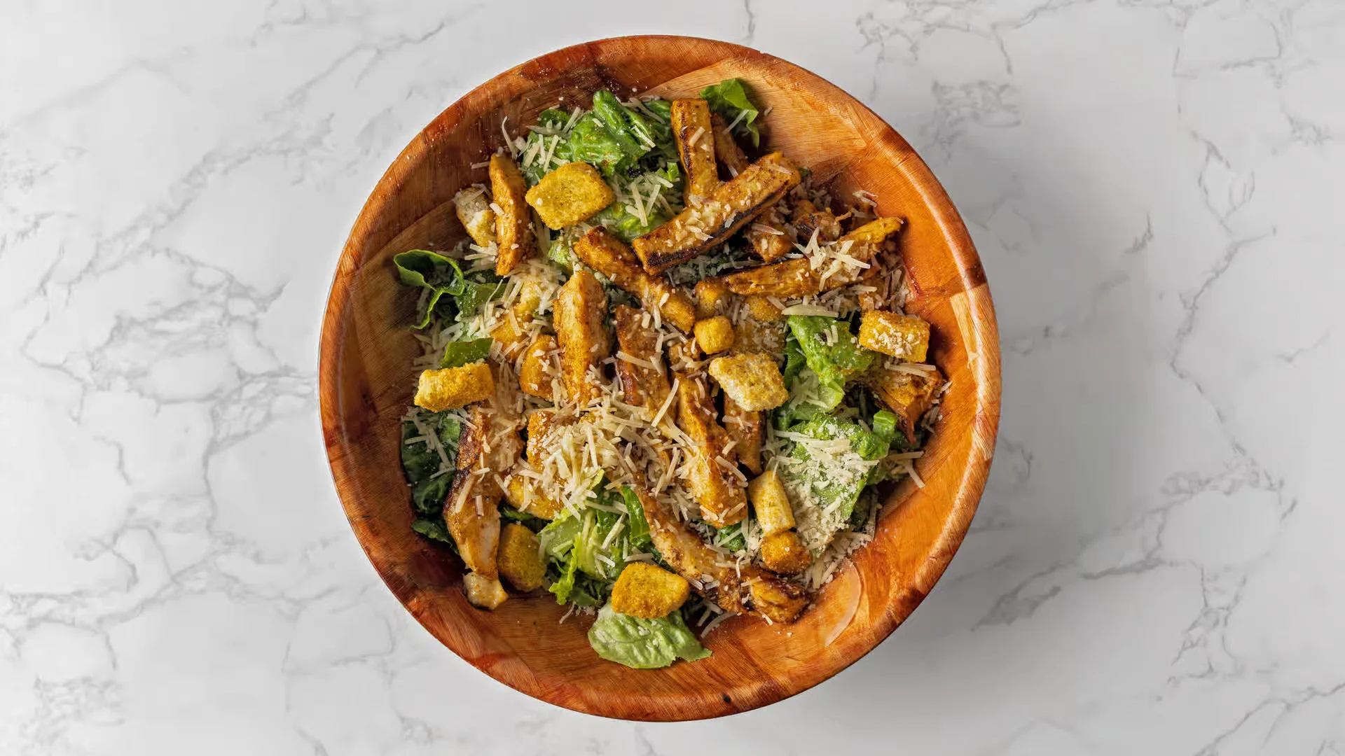 The best, fresh Chicken Caesar Salad at Smackin Js Deli and Grill in Pompano Beach with crisp romaine lettuce, grilled chicken, Parmesan cheese, and crunchy croutons.