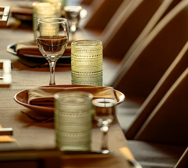 Elegant dining setup with glasses and green candle holders on a table.