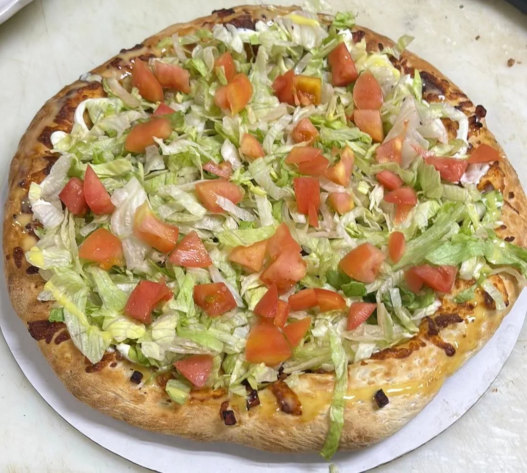 Fresh taco pizza topped with lettuce and tomatoes