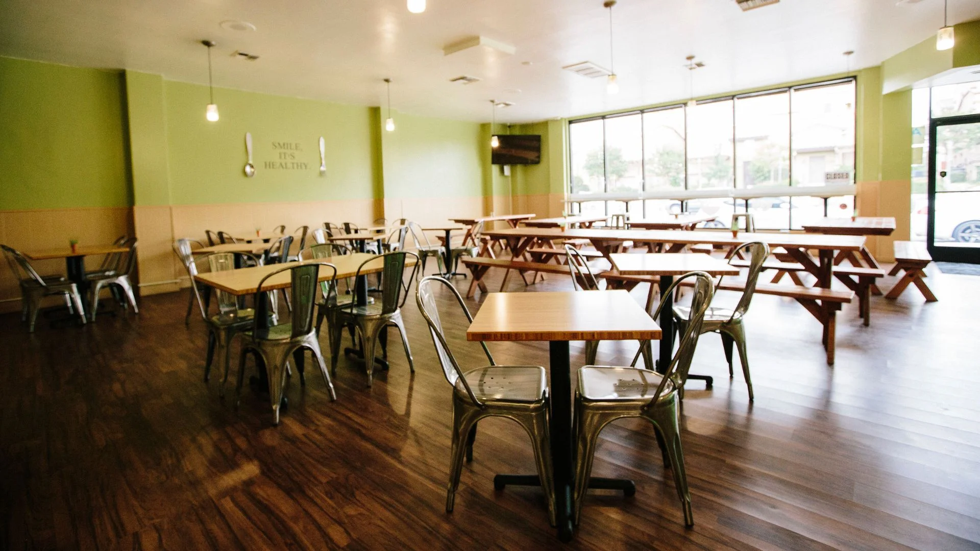 Cozy restaurant interior with wooden tables and green walls
